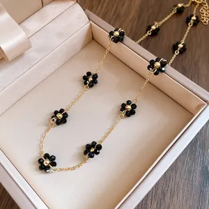 Dettaglio elegante di una collana vintage in oro con perline a fiore in cristallo nero
