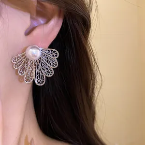 Detailed view of elegant hollow silver leaf earrings featuring a large white pearl