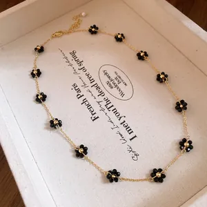 Collana vintage con fiori di cristallo nero e catena dorata sottile dallo stile chic.