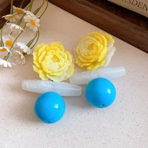 Close-up detail of vintage resin flower earrings with blue spherical pendants.