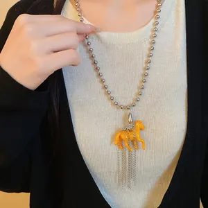 Detailed view of a unique resin horse pendant necklace with silver chain and tassels