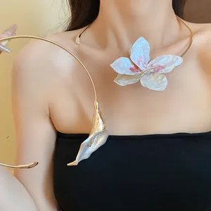 Detailed view of a gold metal choker with elegant white spray-painted flower accents