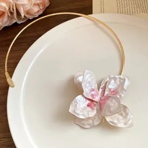 Close-up of vintage metal circular choker with painted floral pendant and hammered petals