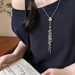 Elegant silver necklace featuring multi-layered waterdrop tassels on a black top