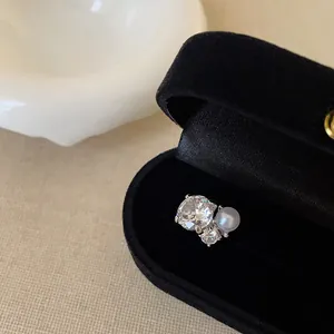 Detailaufnahme eines eleganten Zirkon-Perlen-Ohrclips in einer schwarzen Schatulle