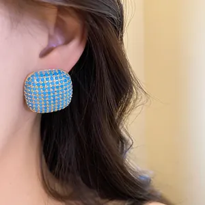 Detailed close-up of a vintage square earring set with vibrant blue pavé stones.