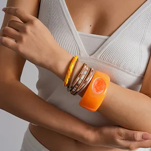 Multi-layer leather wrap bracelet set with wide orange floral resin bangle details.
