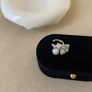 Detailansicht eines luxuriösen Silber-Ohrclips mit glänzendem Zirkon und Perle.