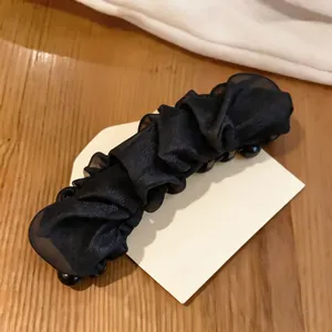 Detailed view of the elegant black pleated mesh fabric on a vertical hair claw clip
