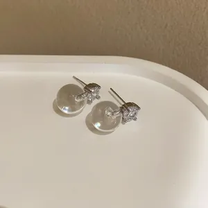 Dettaglio di eleganti orecchini a lobo in zircone con chiusure a sfera trasparenti