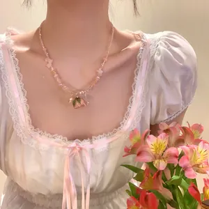 Vista dettagliata di una collana di perle di cristallo rosa con ciondolo di rosa.