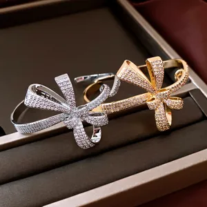 Close-up detail of 18K gold plated bow bangles encrusted with sparkling cubic zirconia
