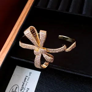 Close-up of elegant 18K gold plated bow cuff bracelet with sparkling zirconia pavé setting