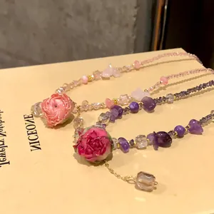 Dettaglio ravvicinato della rosa stabilizzata e della collana di perline di cristallo