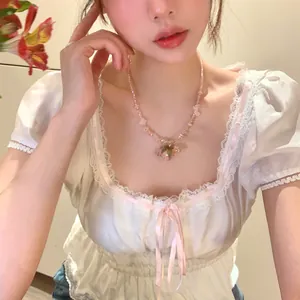 Primo piano di una collana di perle di cristallo rosa con ciondolo a rosa stabilizzata.