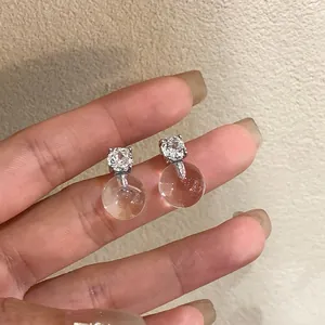 Dettaglio di orecchini in argento con zirconi e sfere di vetro trasparente