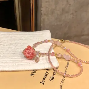 Dettaglio raffinato di una collana di perline di cristallo rosa con pendente a rosa