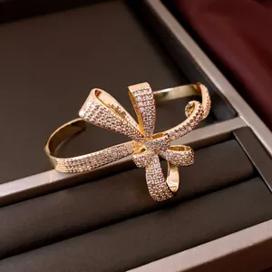 Detailed macro view of 18K gold plated bow-knot bangle pavé-set with sparkling zircons