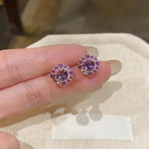 Primo piano di orecchini a lobo tondi in zirconia viola placcati in oro rosa