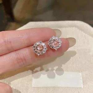 Eleganti orecchini a lobo tondi con zircone color pesca e un alone di pietre brillanti