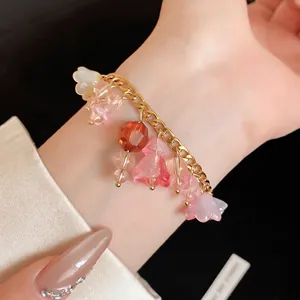 Elegante roestvrijstalen armband met bedeltjes van harsbloemen om een slanke pols