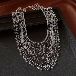 Detailed view of intricate silver fringe necklace with crystal beads on black display.