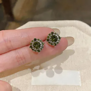 Primo piano di eleganti orecchini a lobo in argento con zirconi verde oliva brillanti