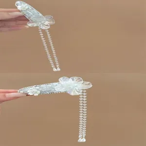 Close-up detail of elegant crystal flower hair clips featuring long iridescent beaded tassels.
