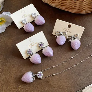 Detailed view of lilac strawberry jewelry set including pearl and crystal earrings