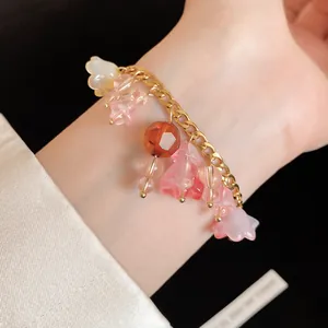 Close-up van een zoete hars bloem armband met een gouden roestvrijstalen ketting