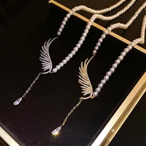 Elegant pearl necklace with zircon-encrusted wings and teardrop pendant