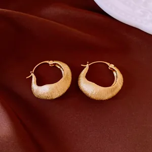 Detailed view of 18K gold-plated circular hoop earrings with brushed metal texture.