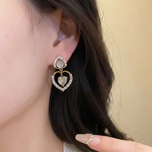Élégantes boucles d'oreilles pendantes double cœur dorées avec oxydes de zirconium