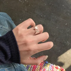 Minimalistischer offener Ring aus Silber mit Seestern und Muschel für den Strandurlaub