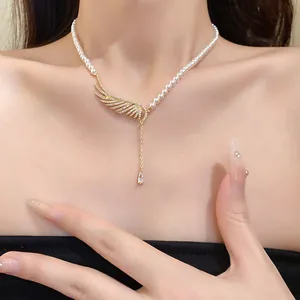 Elegant pearl necklace with zircon wing and waterdrop pendant shown on collarbone.