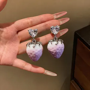 Close-up detail of sweet purple gradient strawberry drop earrings with heart crystal
