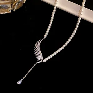 Close-up of elegant pearl necklace featuring a zircon angel wing and waterdrop pendant.