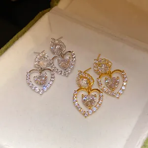 Gros plan exquis de boucles d'oreilles double cœur avec des zircons brillants en cœur