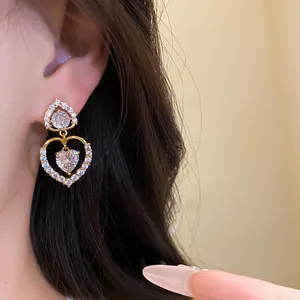 Gros plan de boucles d'oreilles pendantes double cœur avec pierres en zircon étincelantes