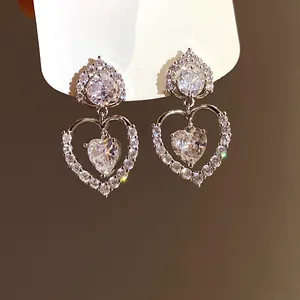 Vue détaillée de boucles d'oreilles pendantes double cœur avec pierres de zircone pavées