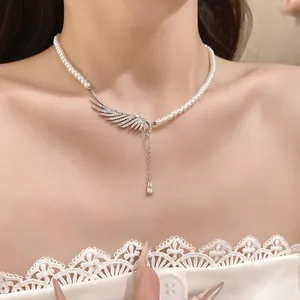 Detailed shot of an elegant zircon pearl necklace featuring a sparkling angel wing pendant