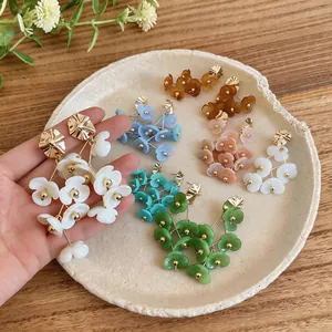 Detail shot of colorful acrylic flower tassel earrings in various vibrant shades and styles.
