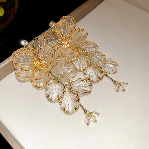 Primo piano di orecchini a fiore con nappe, strass scintillanti e bordi dorati fini.