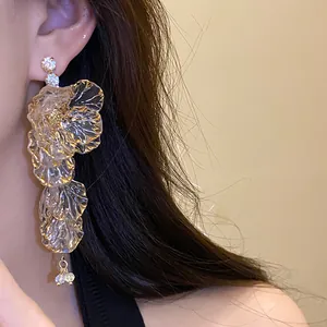 Dettaglio ravvicinato di orecchini vintage a nappa floreale con strass sulla modella