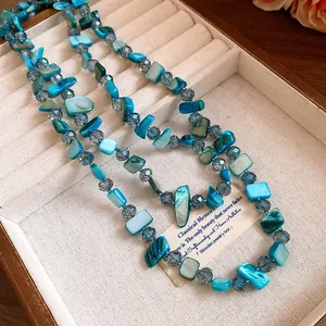 Detail view of blue square shell and crystal beaded layered necklace in jewelry box