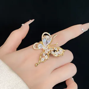 Vista dettagliata di un anello a farfalla dorato con zirconi sulla mano di una modella.