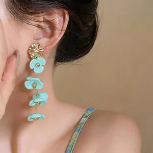 Close-up of dopamine style acrylic flower tassel earrings on a model's ear