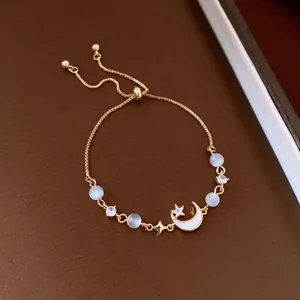 Close-up of French vintage gold bracelet with moon star charms and cat eye stones