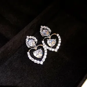 Gros plan détaillé de boucles d'oreilles cœur en argent avec zircons brillants