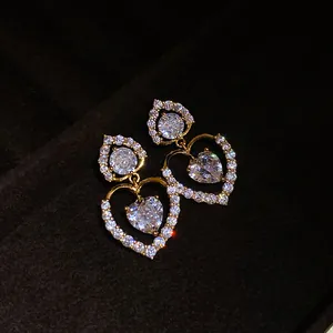 Boucles d'oreilles pendantes double cœur dorées avec zircons clairs scintillants